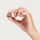 A hand holding one piece of Topper or Treat