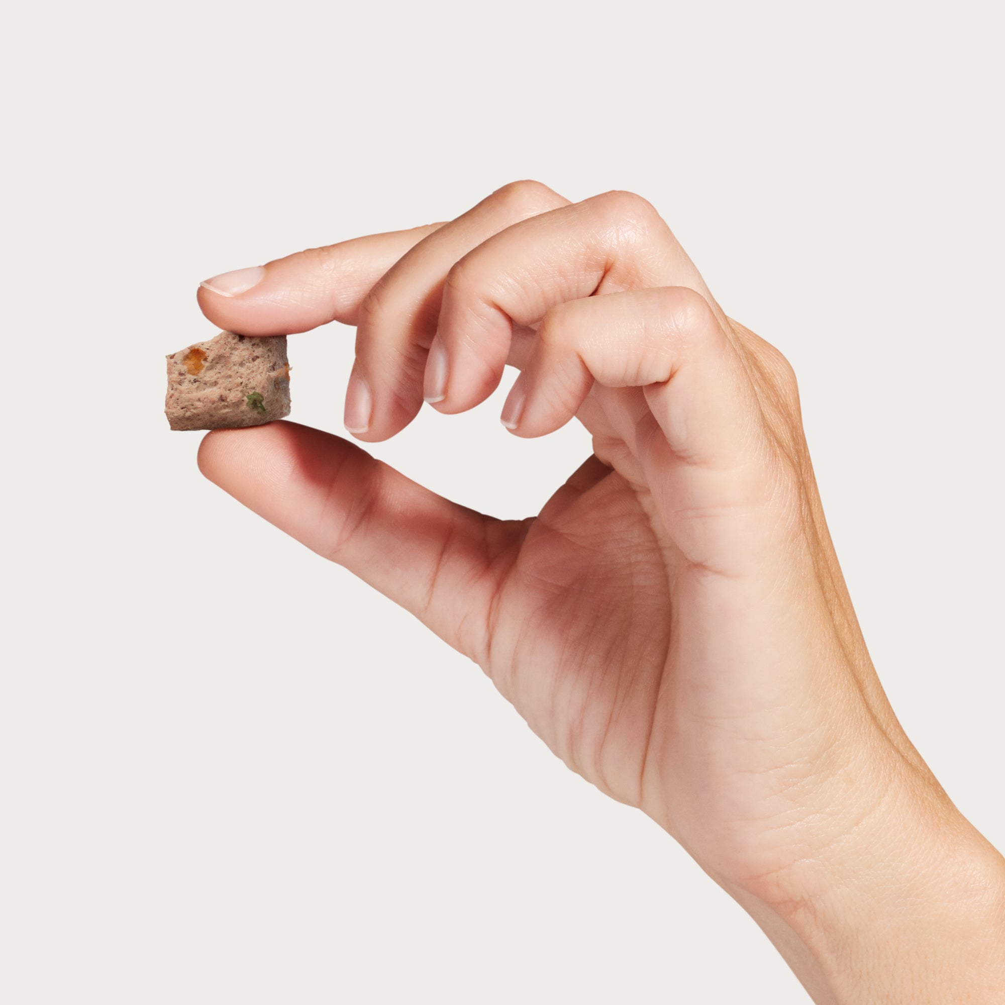 A hand holding one piece of Topper or Treat